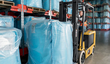 Driver lifting bagged material with Cat cushion tire lift truck